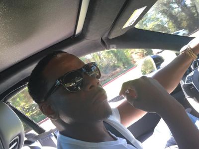 Kendu Isaacs is wearing his shade as he is driving his car.
